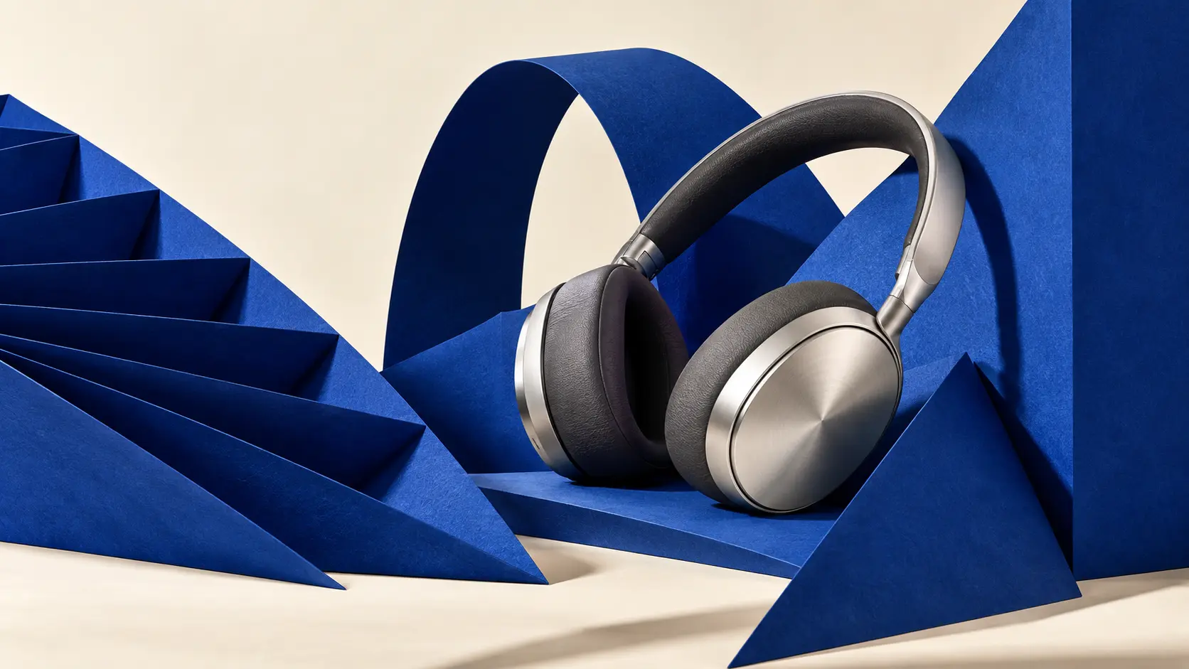 Casque audio argenté dans une composition sculpturale en papier bleu